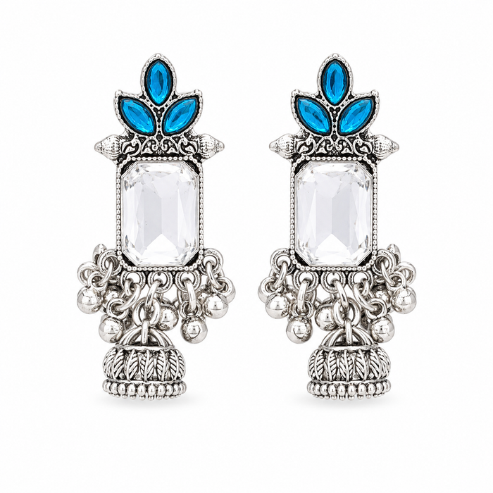A pair of ornate silver-toned statement earrings featuring a large clear rectangular central stone, blue teardrop-shaped stones at the top, and detailed silver filigree and beadwork below, shown on a plain white background.