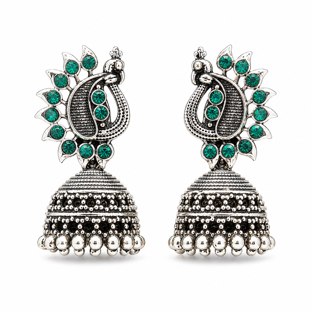 Oxidised silver peacock jhumka earrings with green stones on white background