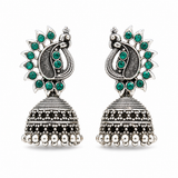 Oxidised silver peacock jhumka earrings with green stones on white background