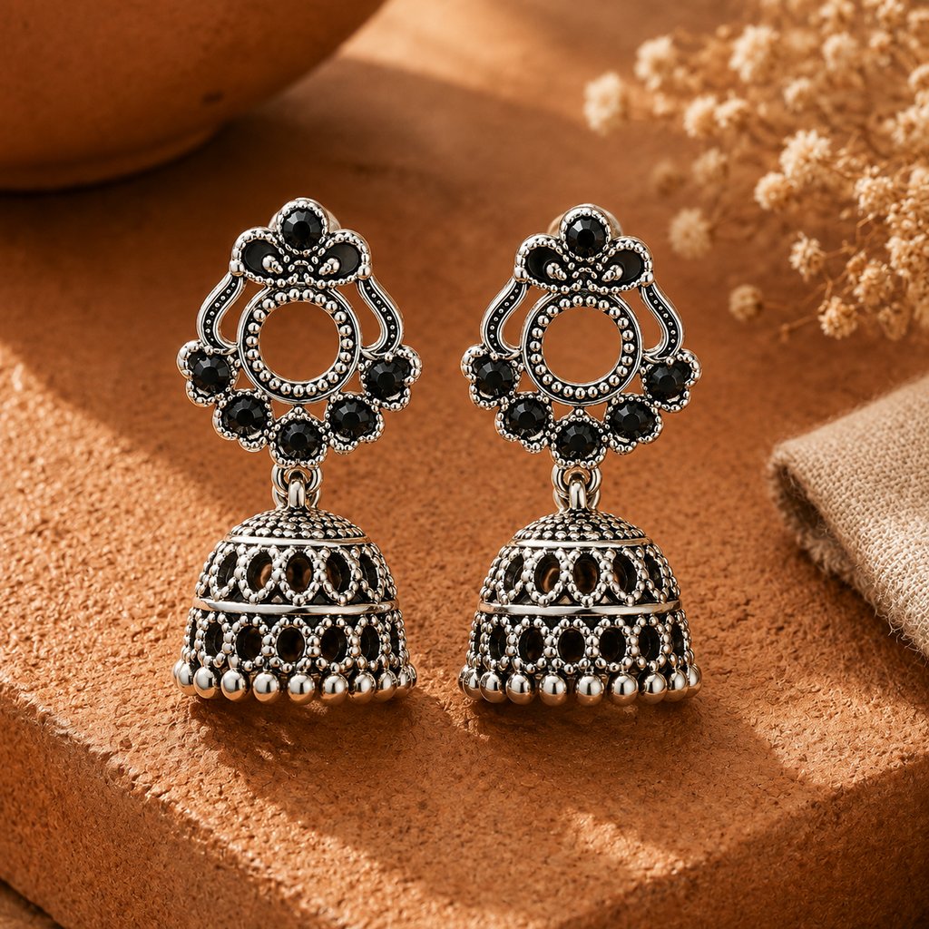 Oxidised silver jhumka earrings with black stones and fan top on terracotta