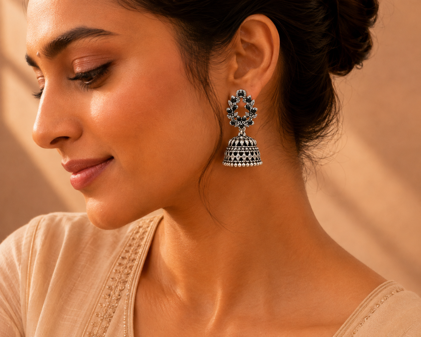 Model wearing oxidised silver black stone leaf wreath jhumka earrings