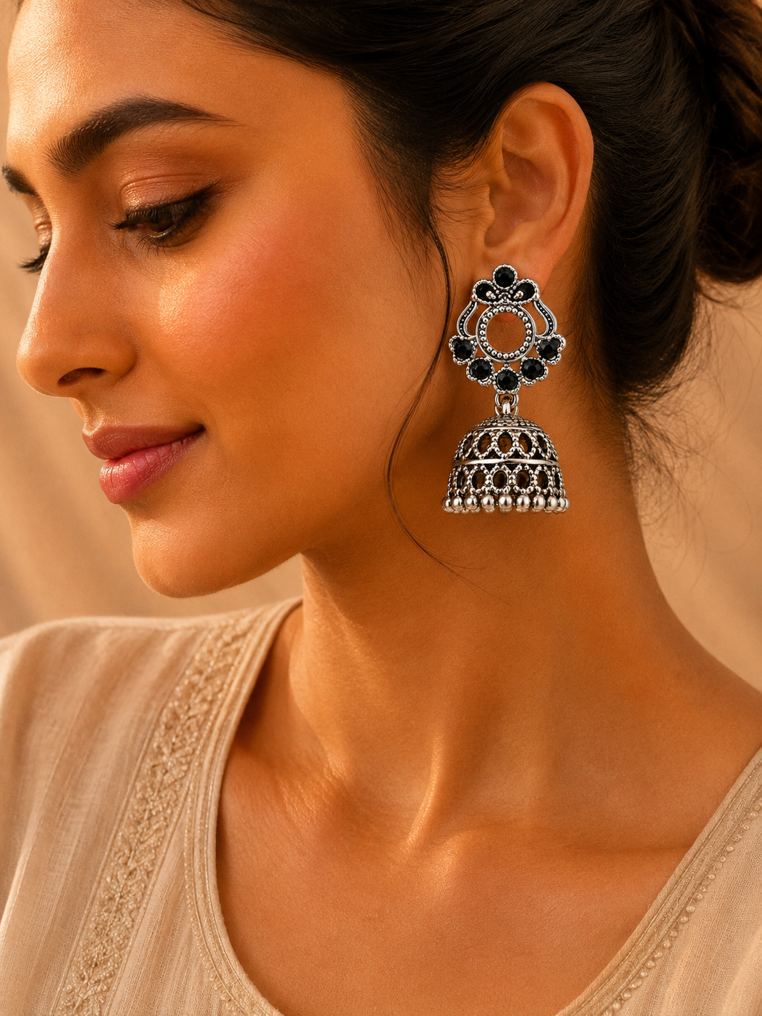 Model wearing oxidised silver black stone jhumka earrings with fan top