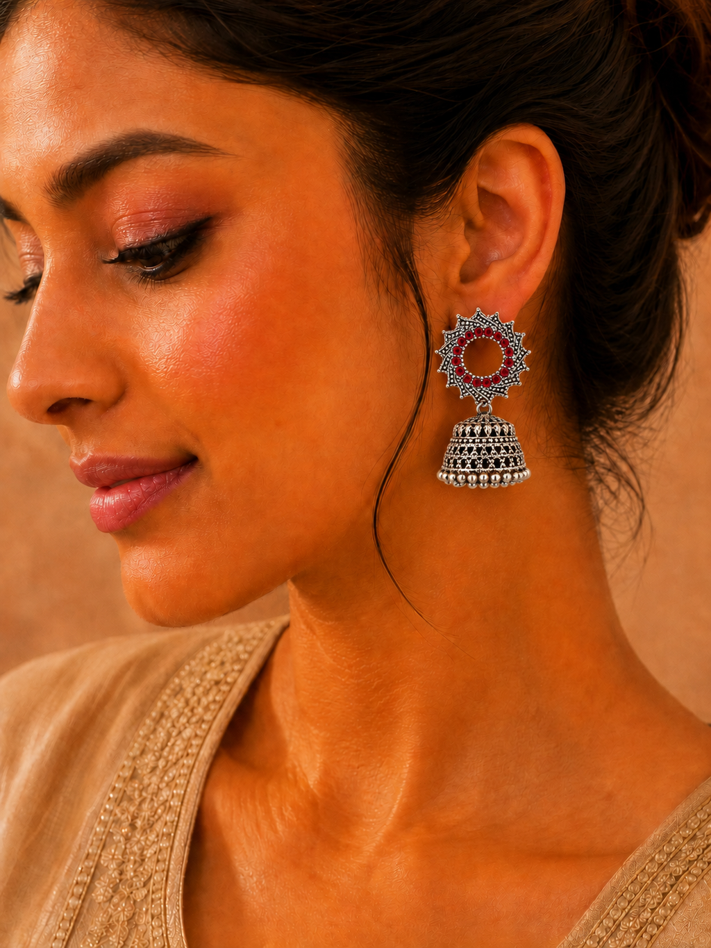 Model wearing oxidised silver red stone sunburst jhumka earrings