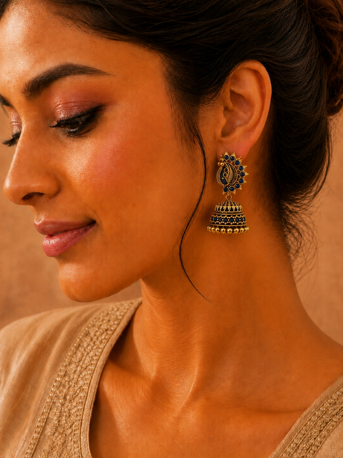Model wearing antique gold blue stone peacock jhumka earrings