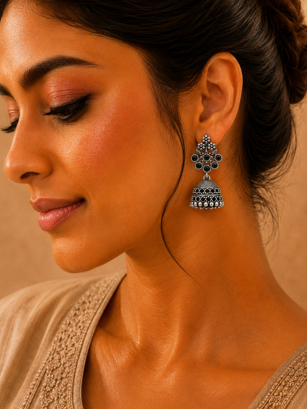 Model wearing oxidised silver floral jhumka earrings with black stones
