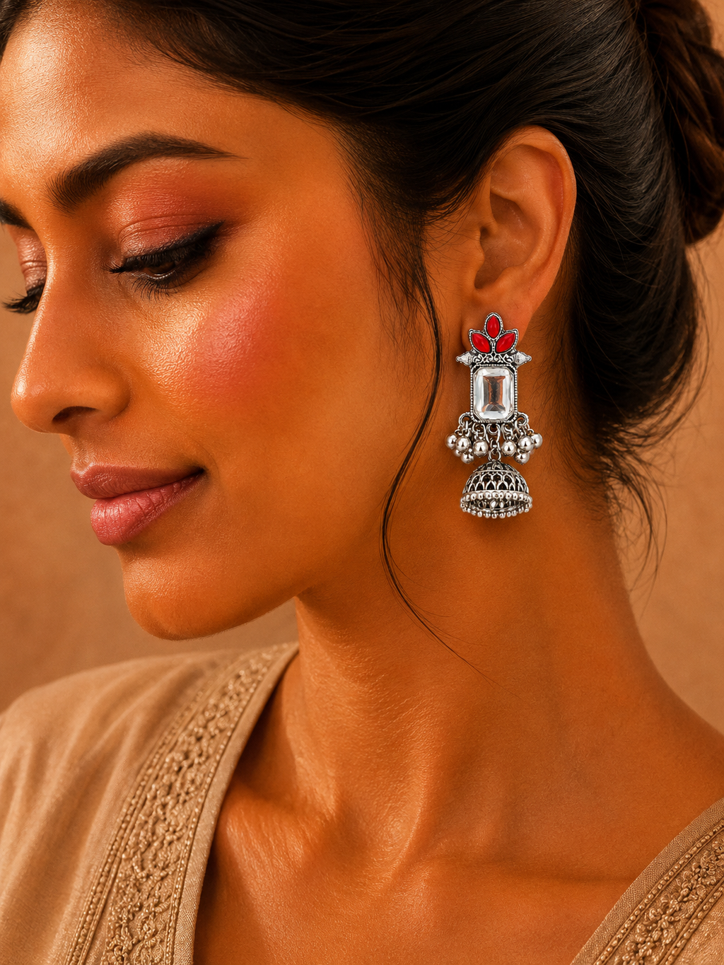 Model wearing oxidised silver red stone jhumka earrings close up