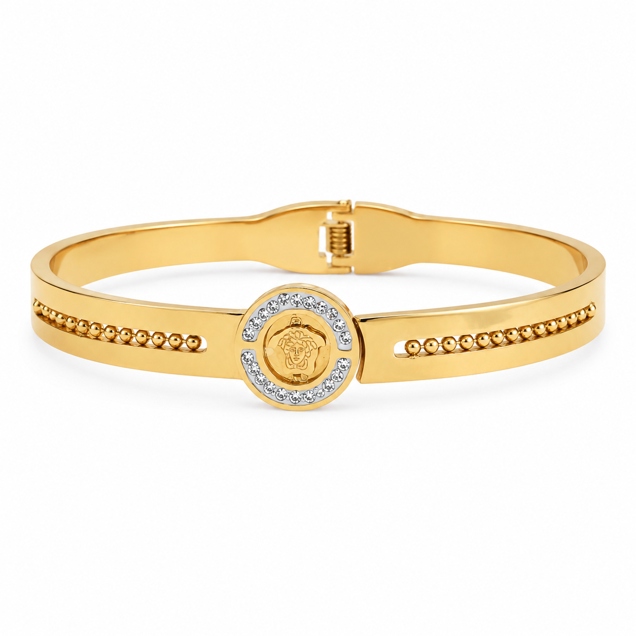 Gold-plated medallion bangle bracelet resting on a wooden surface
