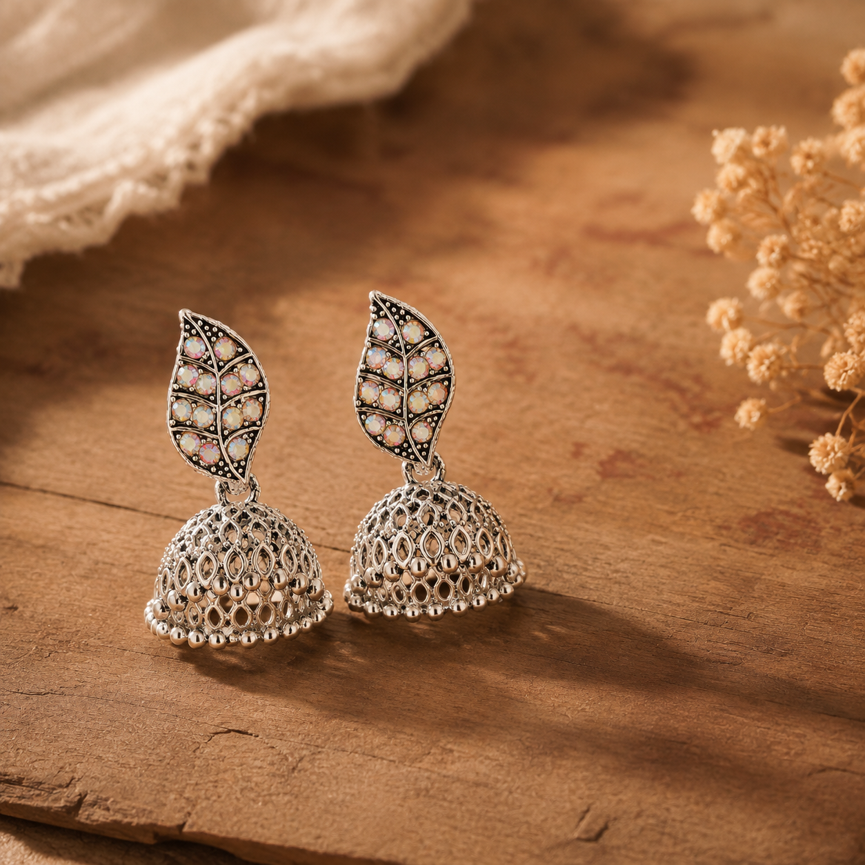 Close-up of a silver oxidised leaf jhumka earring with beaded mesh dome