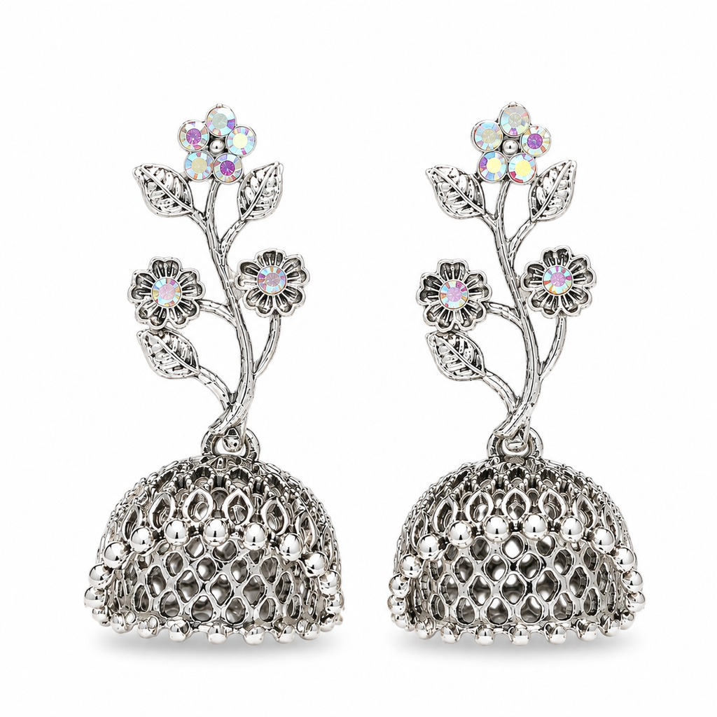 A pair of silver-toned jhumka earrings with floral motifs and iridescent rhinestone flowers, shown on a plain white background.