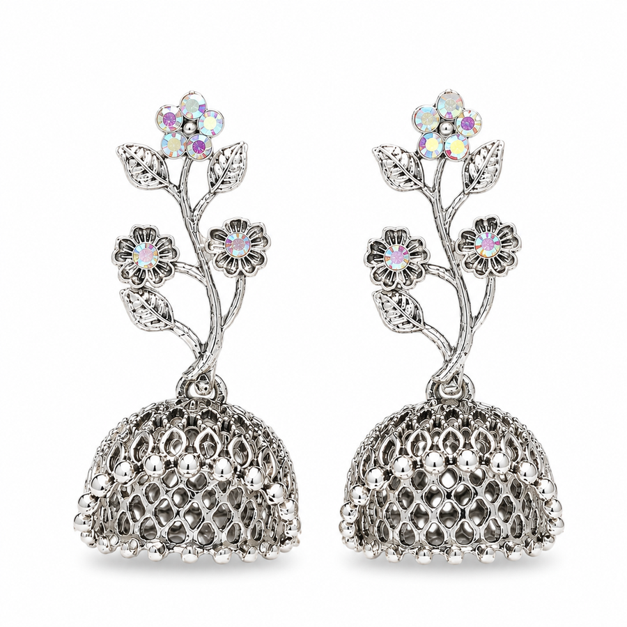 A pair of silver-toned jhumka earrings with floral motifs and iridescent rhinestone flowers, shown on a plain white background.