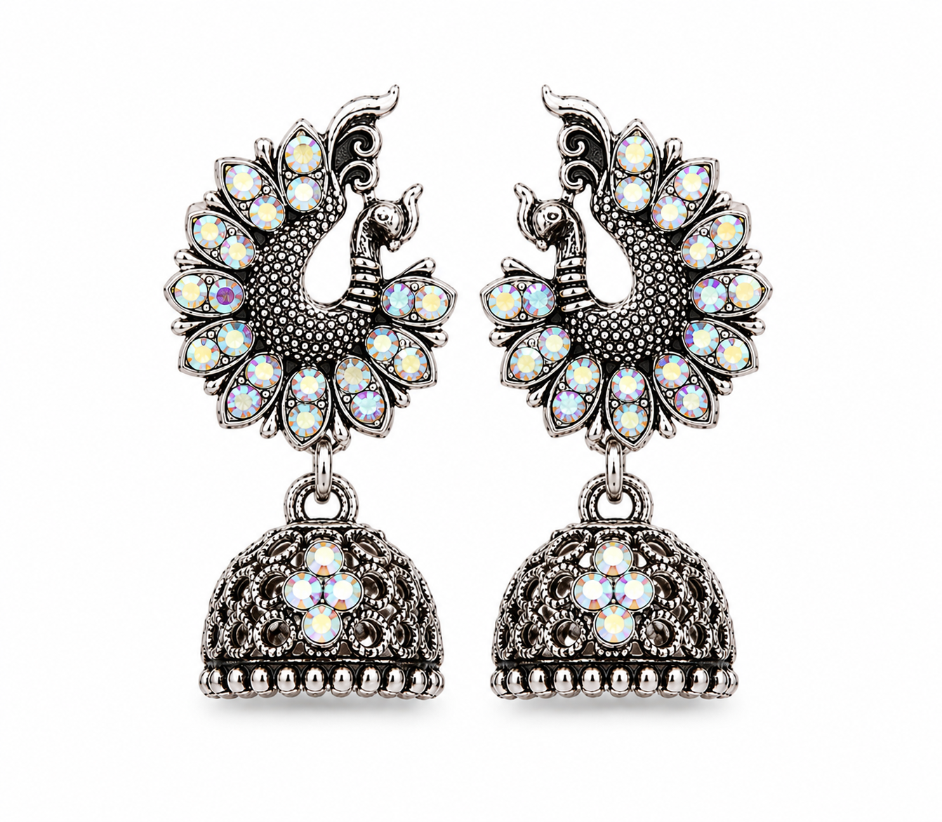 A pair of silver-toned Jhumka earrings featuring peacock motifs adorned with iridescent white and multicolor stones, hanging from ornate filigree bell-shaped drops on a plain white background.
