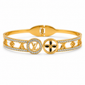 Gold-tone openwork bangle bracelet with crystal-studded cut-out design