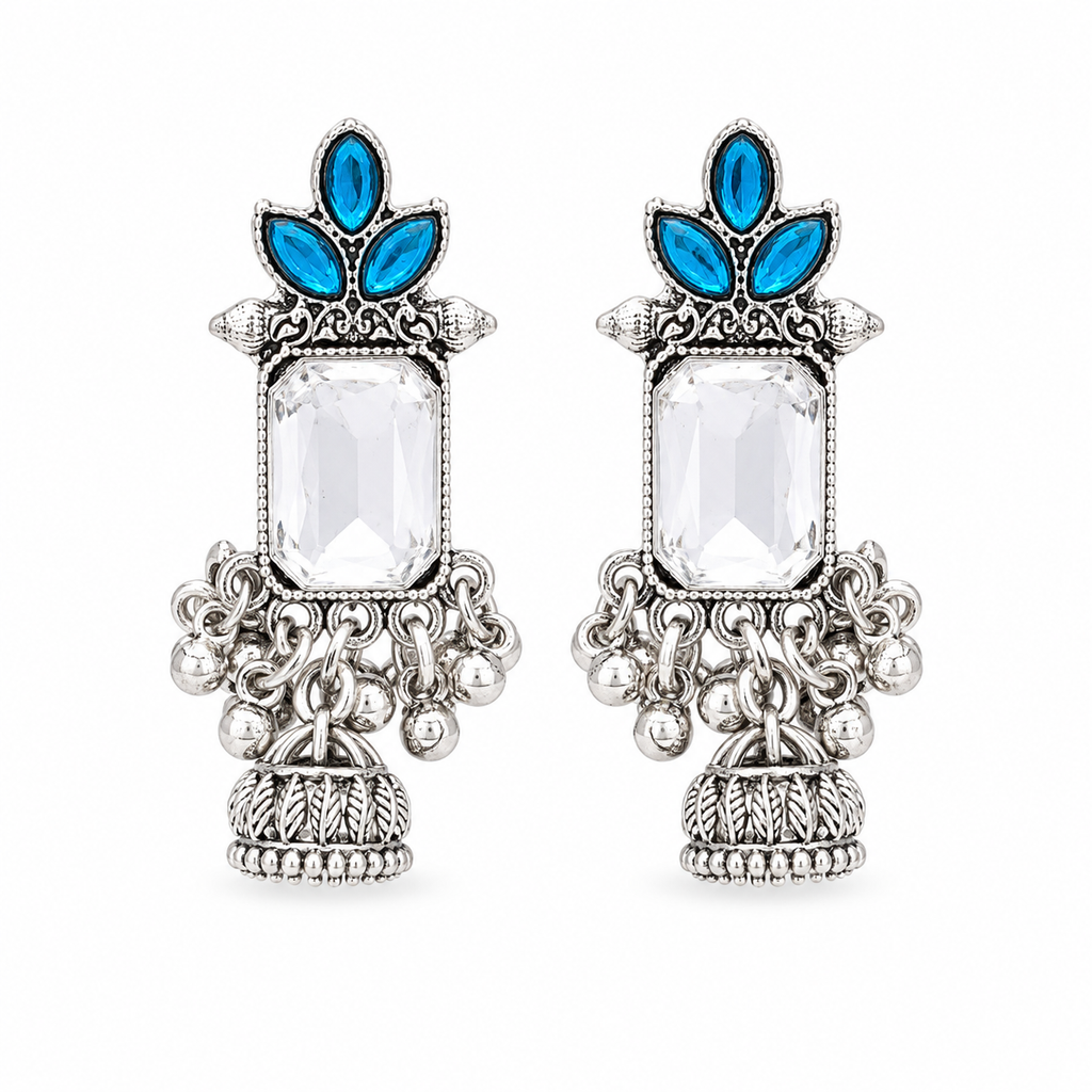 A pair of ornate silver-toned statement earrings featuring a large clear rectangular central stone, blue teardrop-shaped stones at the top, and detailed silver filigree and beadwork below, shown on a plain white background.