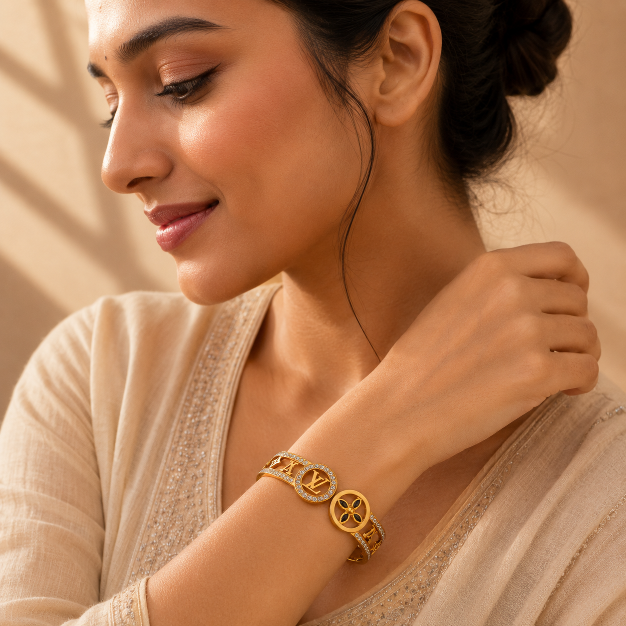 Gold-tone openwork statement bangle worn on a wrist